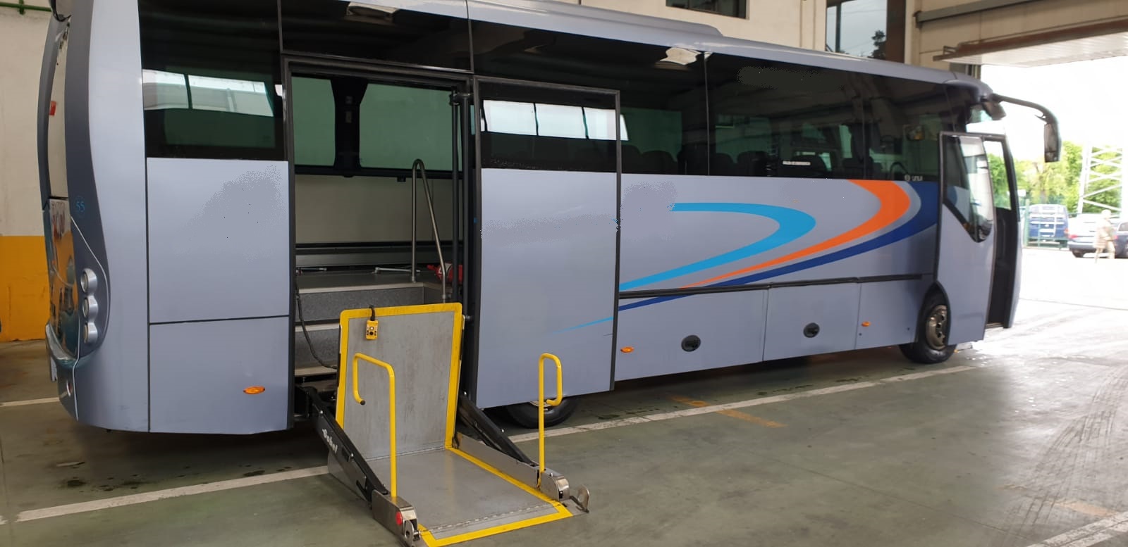 Microbús blanco de Microbuses Núñez con la puerta lateral abierta y la plataforma elevadora desplegada para sillas de ruedas
