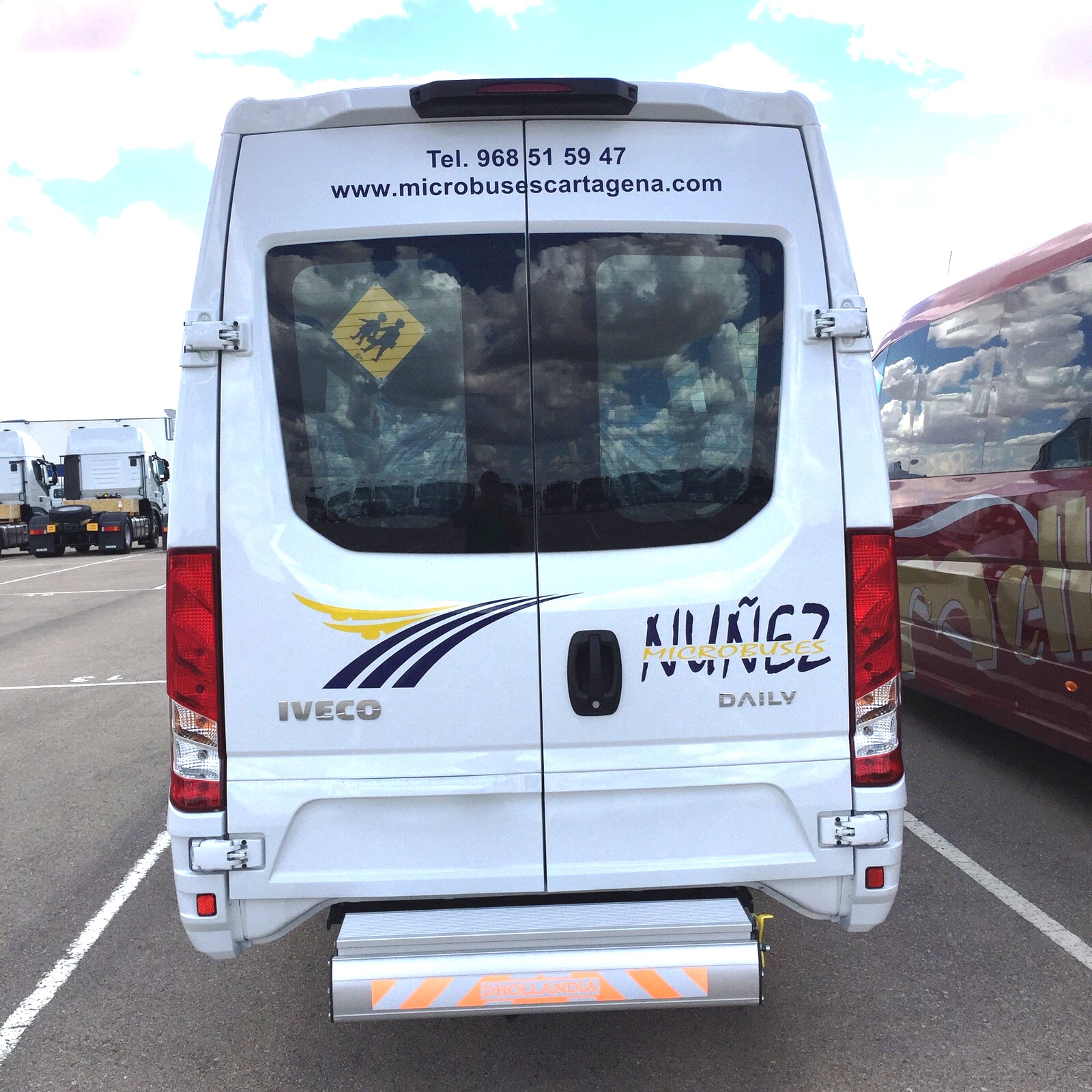 Parte trasera de un microbús Iveco Daily de Microbuses Núñez con la plataforma elevadora plegada bajo el portón